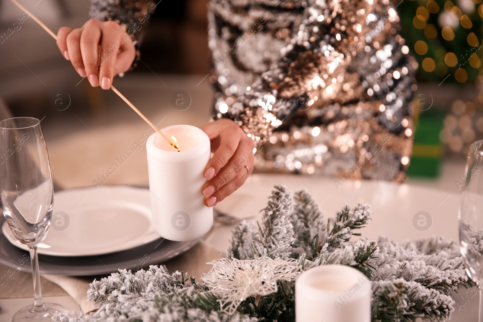 Young woman setting table for Christmas dinner indoors, closeup Photo of Young woman setting table for Christmas dinner indoors, closeup