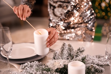 Young woman setting table for Christmas dinner indoors, closeup Photo of Young woman setting table for Christmas dinner indoors, closeup