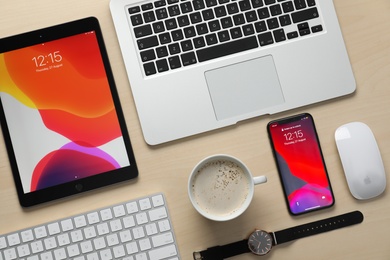 MYKOLAIV, UKRAINE - AUGUST 27, 2020: Flat lay composition with iPhone 11, MacBook laptop and iPad tablet on wooden table Photo of MYKOLAIV, UKRAINE - AUGUST 27, 2020: Flat lay composition with iPhone 11, MacBook laptop and iPad tablet on wooden table