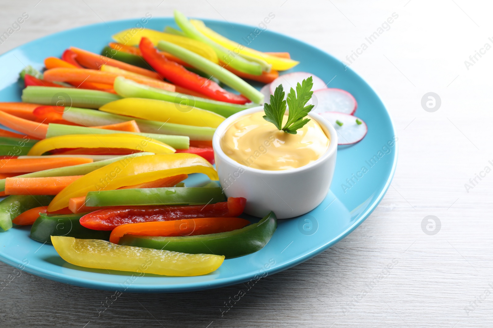 Different vegetables cut in sticks and dip sauce on grey wooden table, closeup Photo of Different vegetables cut in sticks and dip sauce on grey wooden table, closeup