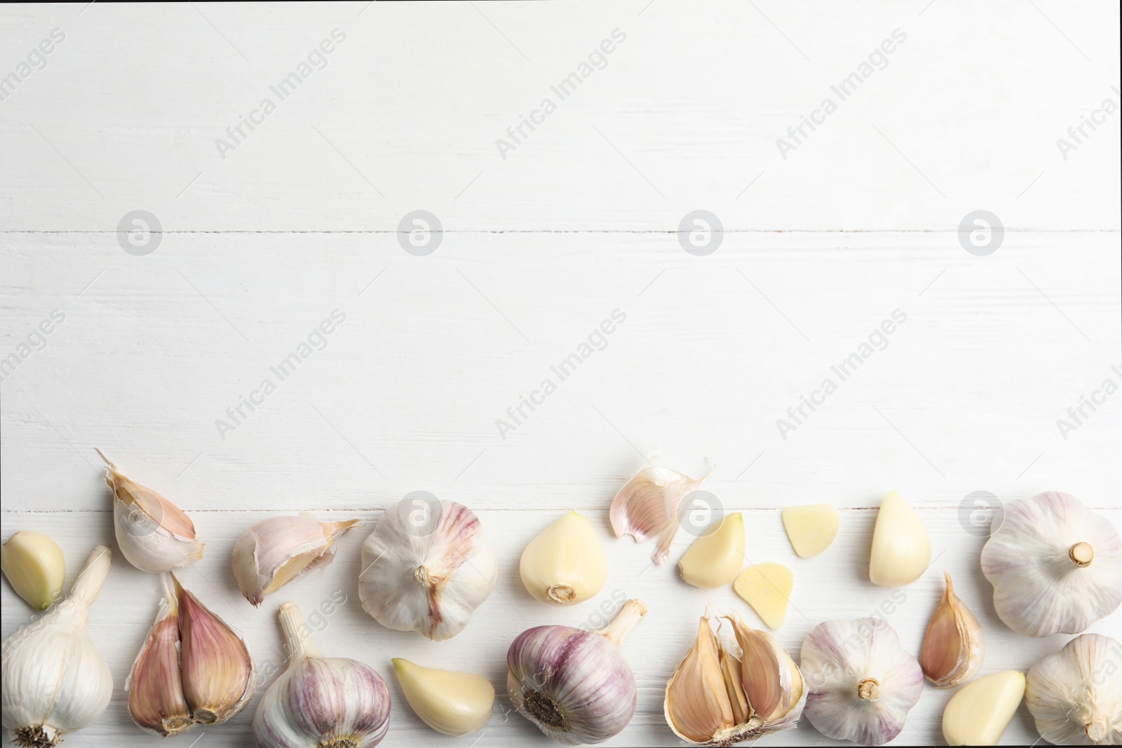 Fresh organic garlic on white wooden table, flat lay. Space for text Photo of Fresh organic garlic on white wooden table, flat lay. Space for text