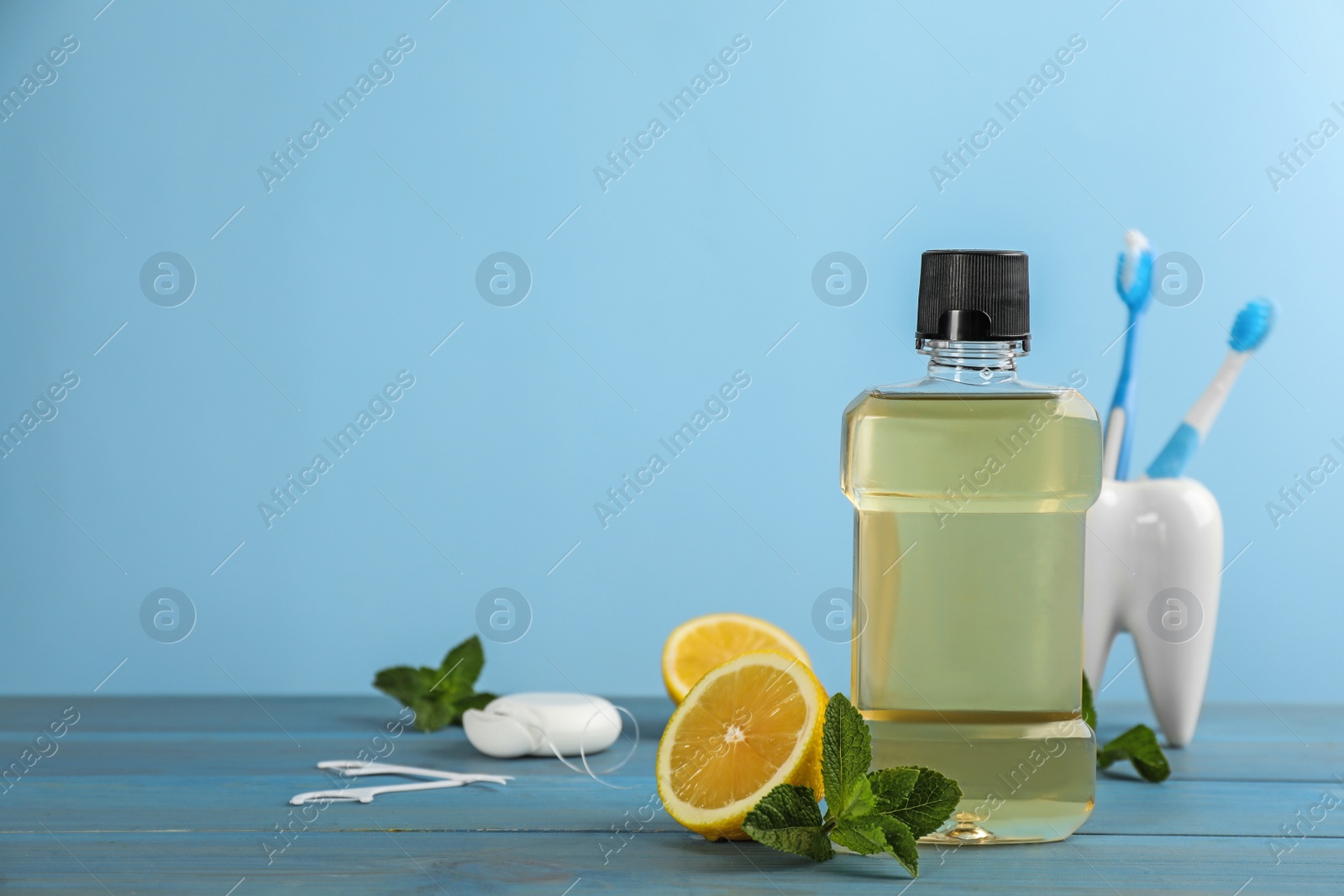 Mouthwash and other oral hygiene products on light blue wooden table, space for text Photo of Mouthwash and other oral hygiene products on light blue wooden table, space for text