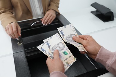 Man with money at cash department window, closeup. Currency exchange Photo of Man with money at cash department window, closeup. Currency exchange
