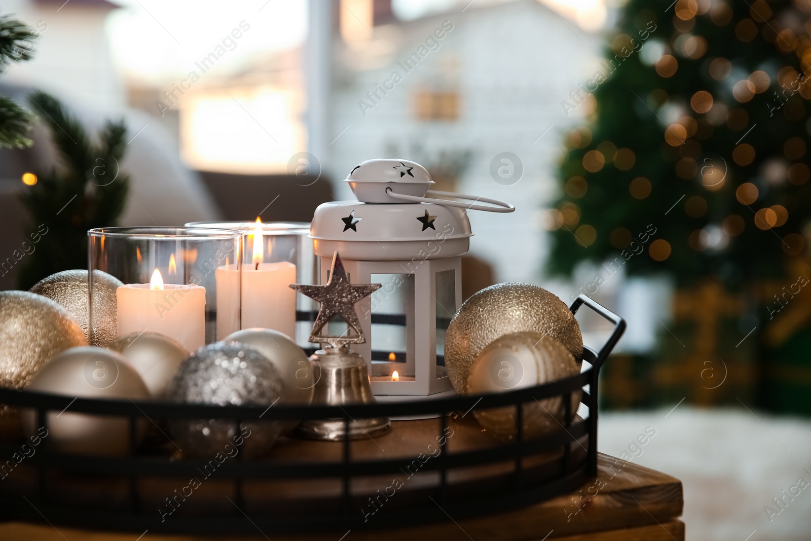 Burning candles, lantern and Christmas balls on wooden table indoors, closeup Photo of Burning candles, lantern and Christmas balls on wooden table indoors, closeup