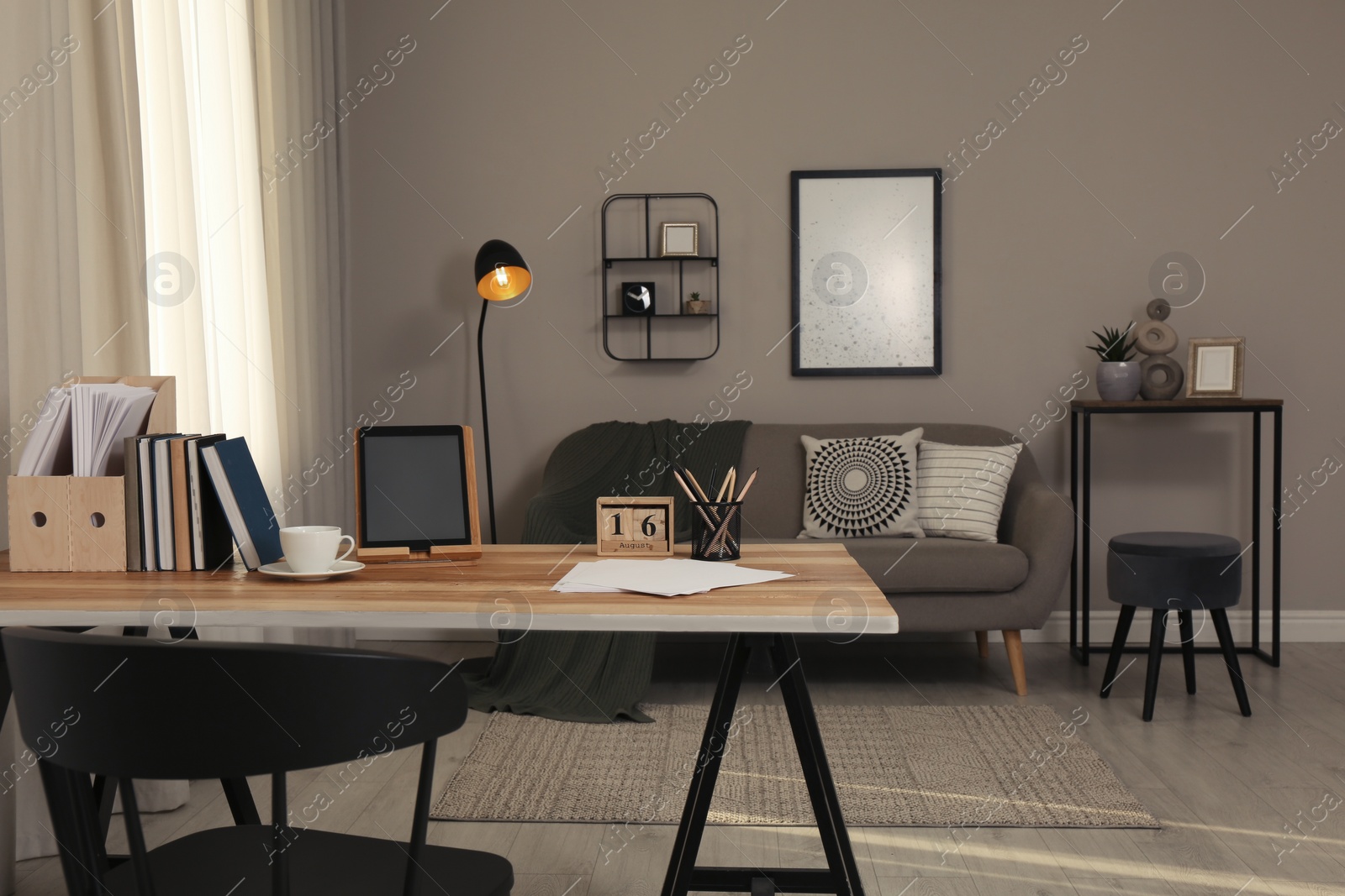 Comfortable workplace with tablet on wooden table in modern office. Interior design Photo of Comfortable workplace with tablet on wooden table in modern office. Interior design