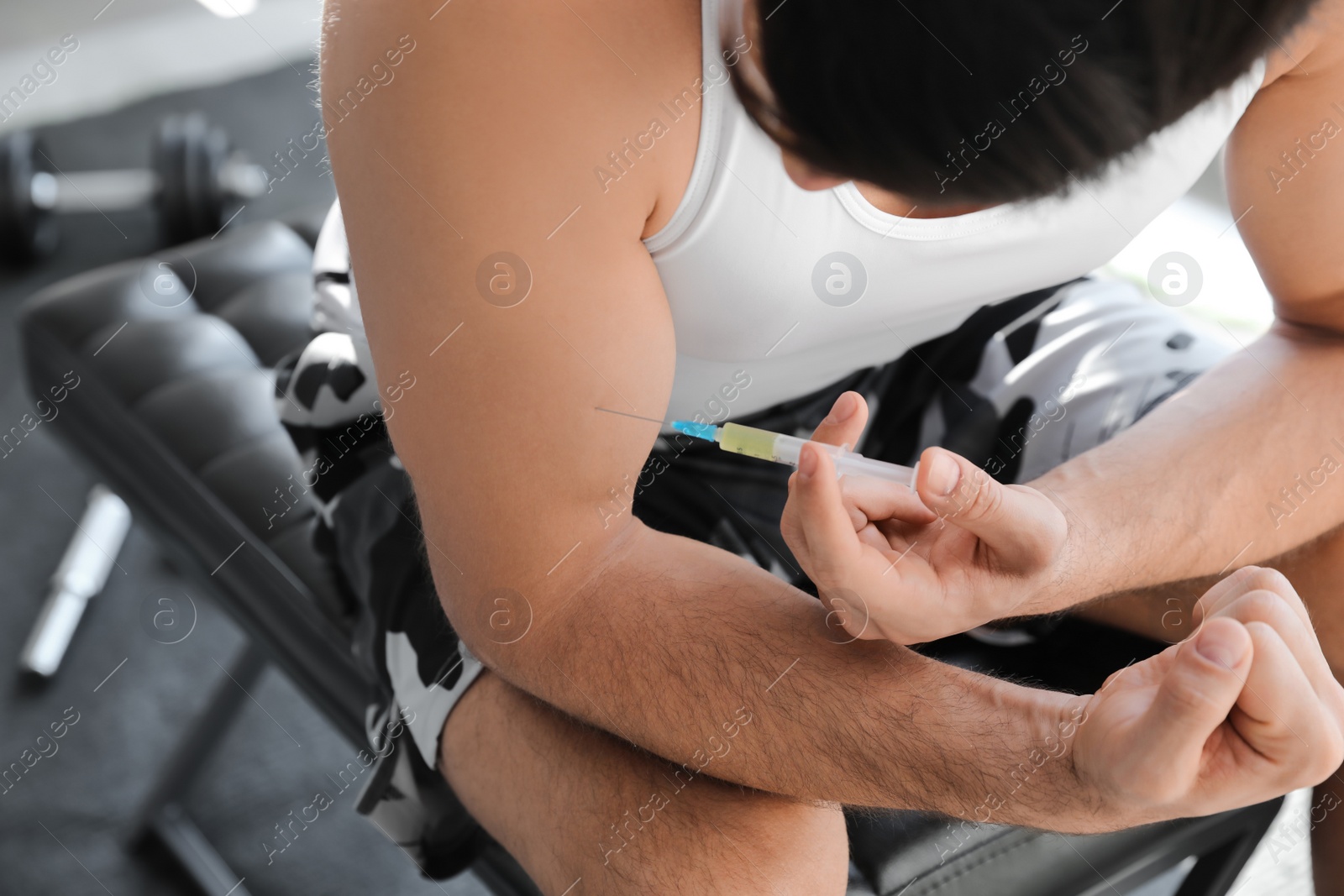 Sportsman injecting himself in gym, closeup. Doping concept Photo of Sportsman injecting himself in gym, closeup. Doping concept