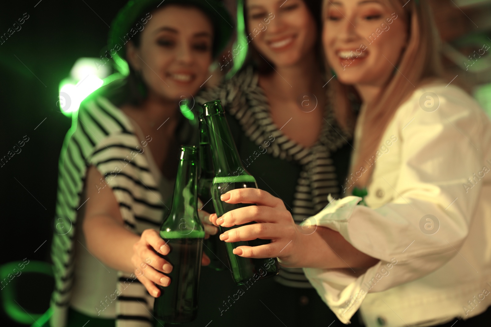 Women with beer celebrating St Patrick's day in pub, focus on hands Photo of Women with beer celebrating St Patrick's day in pub, focus on hands