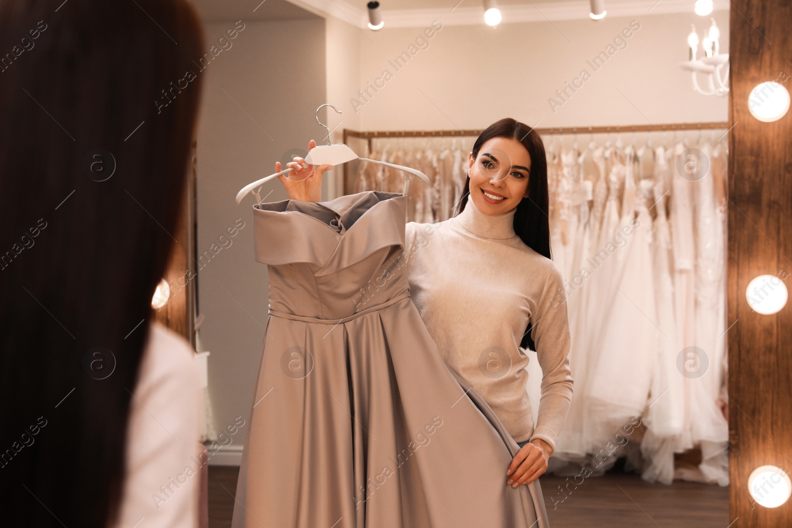 Woman choosing dress in rental clothing salon Photo of Woman choosing dress in rental clothing salon