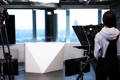 Photo of Professional video camera operator working in studio, space for text