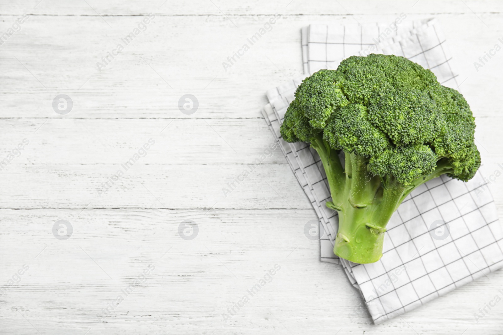 Fresh green broccoli on white wooden table, top view. Space for text Photo of Fresh green broccoli on white wooden table, top view. Space for text