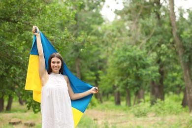 Young woman with flag of Ukraine outdoors Photo of Young woman with flag of Ukraine outdoors