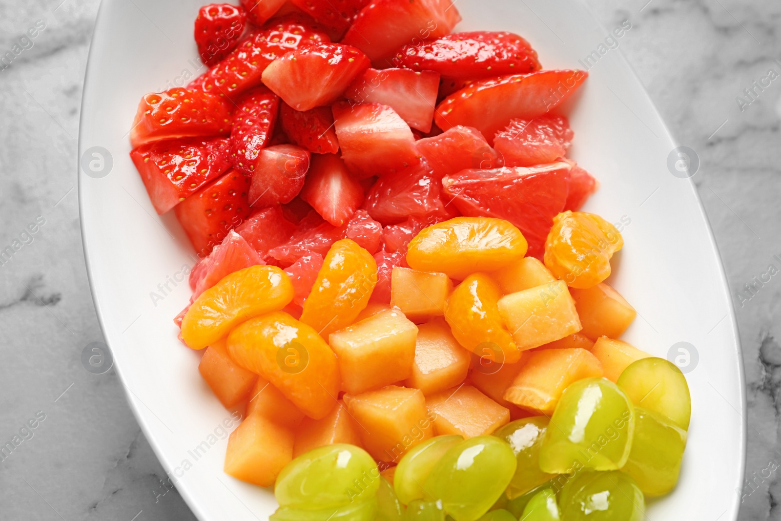 Plate with fresh cut fruits on table, closeup Photo of Plate with fresh cut fruits on table, closeup