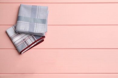 Different handkerchiefs folded on pink wooden table, flat lay. Space for text Photo of Different handkerchiefs folded on pink wooden table, flat lay. Space for text