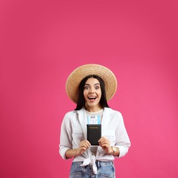 Emotional female tourist with ticket and passport on pink background Photo of Emotional female tourist with ticket and passport on pink background