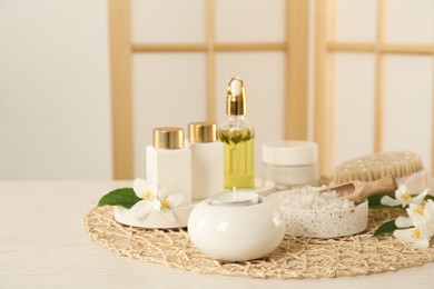 Composition with beautiful jasmine flowers and skin care products on white wooden table indoors Photo of Composition with beautiful jasmine flowers and skin care products on white wooden table indoors