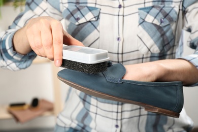 Woman taking care of stylish shoe indoors, closeup Photo of Woman taking care of stylish shoe indoors, closeup