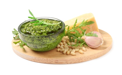 Bowl of tasty arugula pesto and ingredients on white background Photo of Bowl of tasty arugula pesto and ingredients on white background