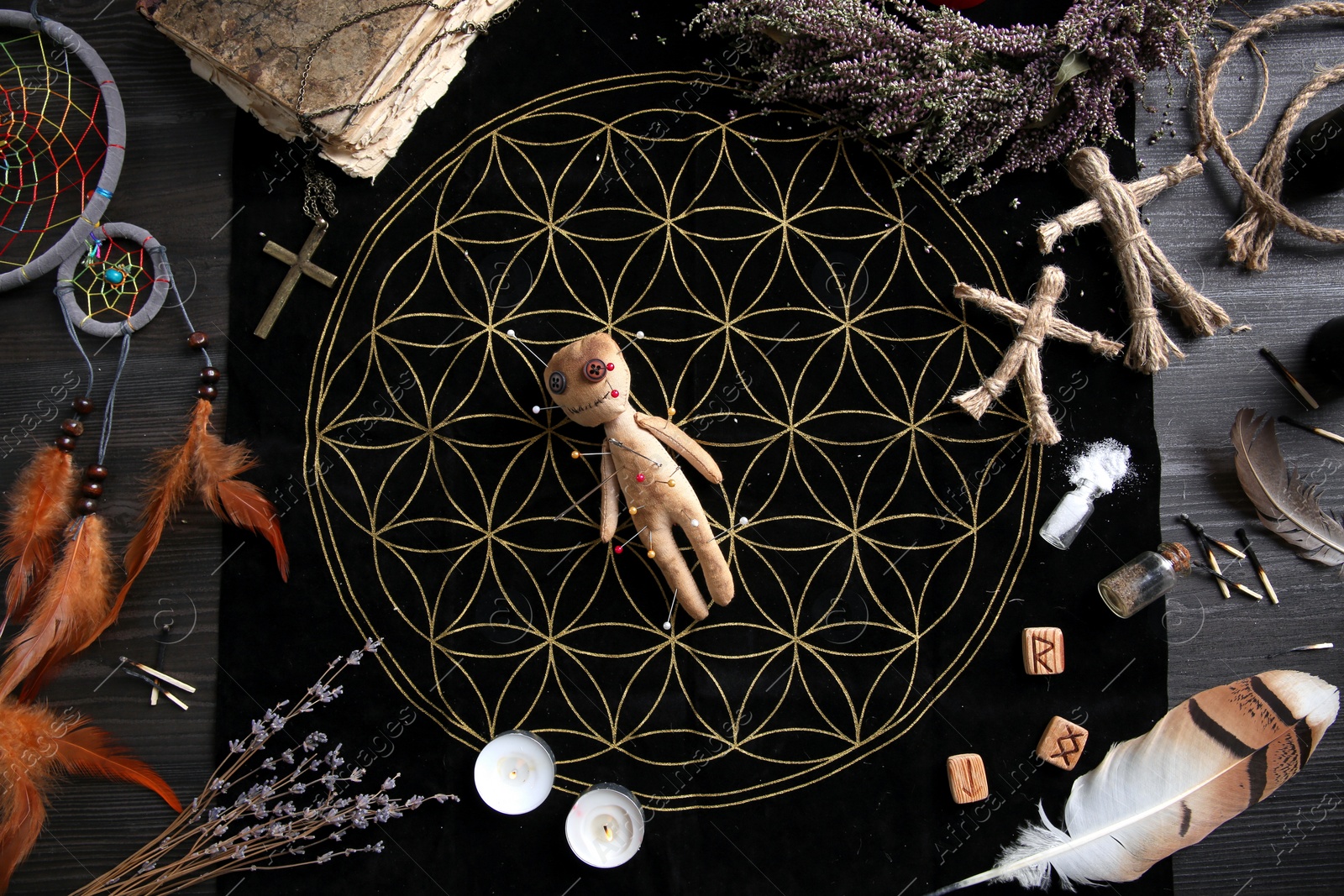 Voodoo doll with pins surrounded by ceremonial items on table, flat lay Photo of Voodoo doll with pins surrounded by ceremonial items on table, flat lay