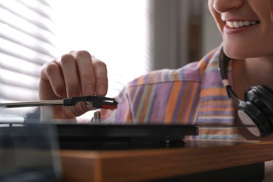 Young woman using turntable at home, closeup Photo of Young woman using turntable at home, closeup