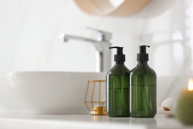 Green soap dispensers on countertop near sink in bathroom. Space for text Photo of Green soap dispensers on countertop near sink in bathroom. Space for text
