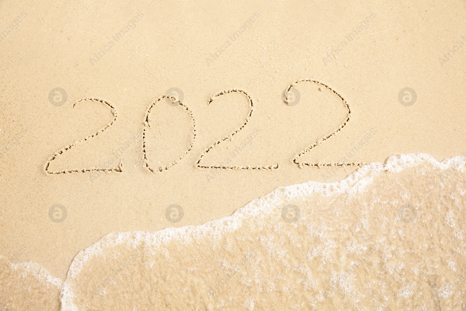 Sandy beach with written 2022 washed by sea. Happy New Year, above view Photo of Sandy beach with written 2022 washed by sea. Happy New Year, above view