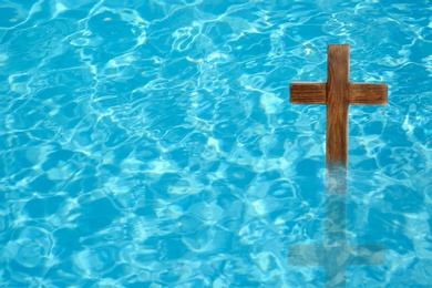 Wooden cross in water for religious ritual known as baptism Image of Wooden cross in water for religious ritual known as baptism