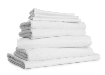 Stack of towels and bed sheets on white background Photo of Stack of towels and bed sheets on white background