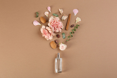 Flat lay composition with bottle of perfume on light brown background Photo of Flat lay composition with bottle of perfume on light brown background