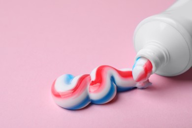 Tube with squeezed out toothpaste on pink background, closeup Photo of Tube with squeezed out toothpaste on pink background, closeup