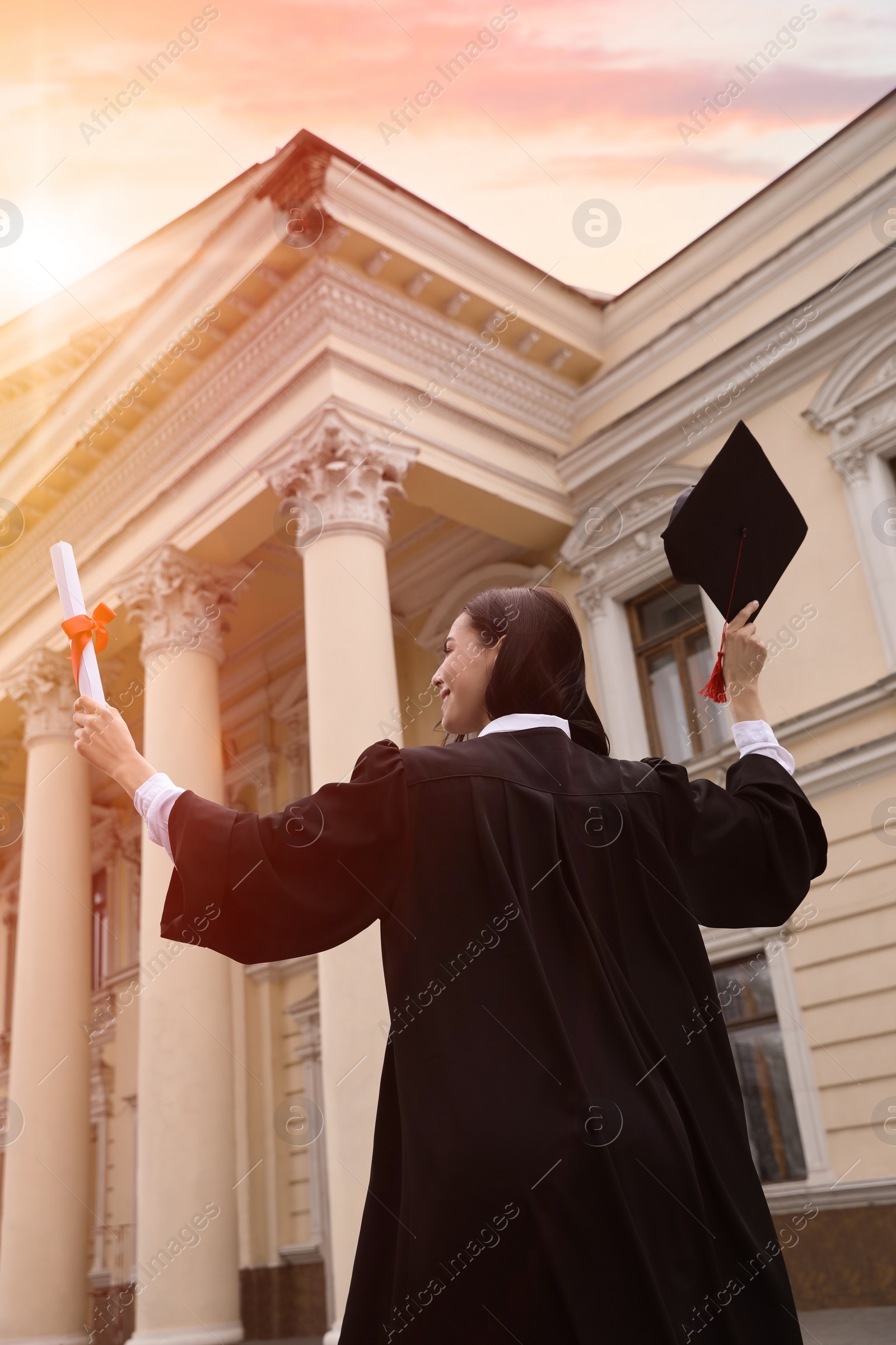 Student with diploma after graduation ceremony outdoors, low angle view Photo of Student with diploma after graduation ceremony outdoors, low angle view