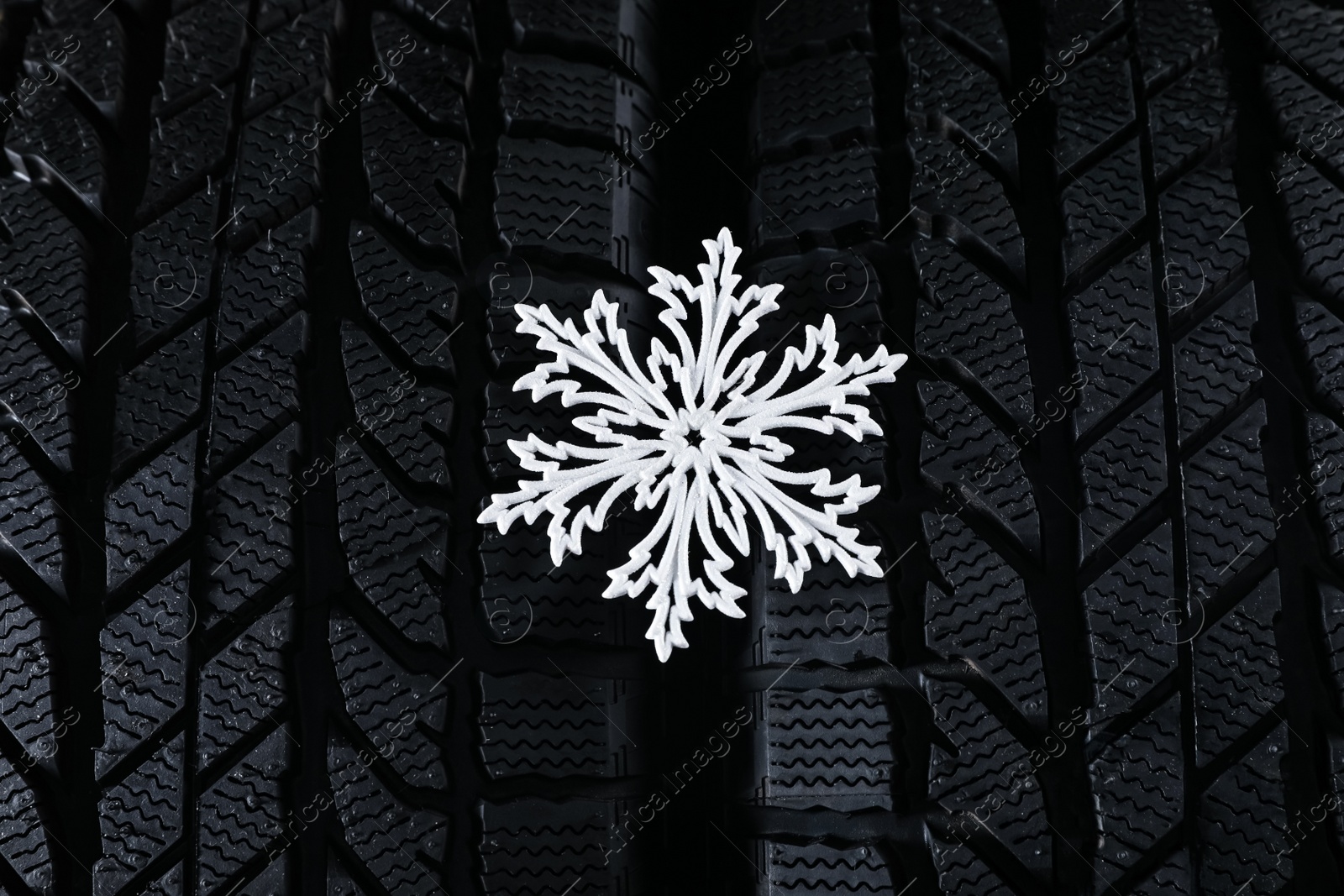 Winter tires with decorative snowflake as background, closeup Photo of Winter tires with decorative snowflake as background, closeup