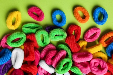 Different colorful hair ties on light green background, flat lay Photo of Different colorful hair ties on light green background, flat lay