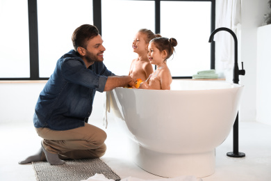 Young father with little daughters in bathroom Photo of Young father with little daughters in bathroom