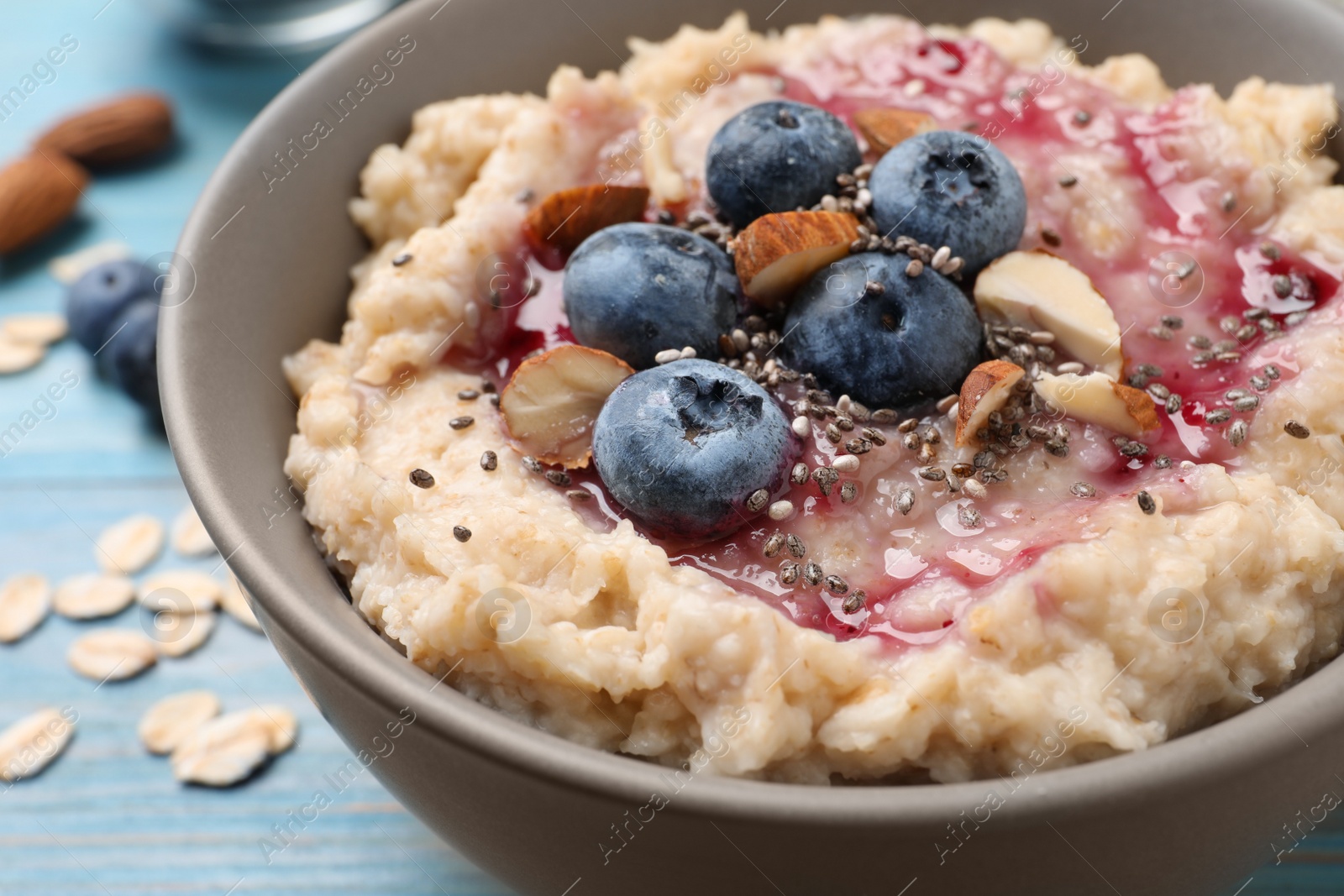 Tasty oatmeal porridge with toppings on light blue wooden table, closeup Photo of Tasty oatmeal porridge with toppings on light blue wooden table, closeup