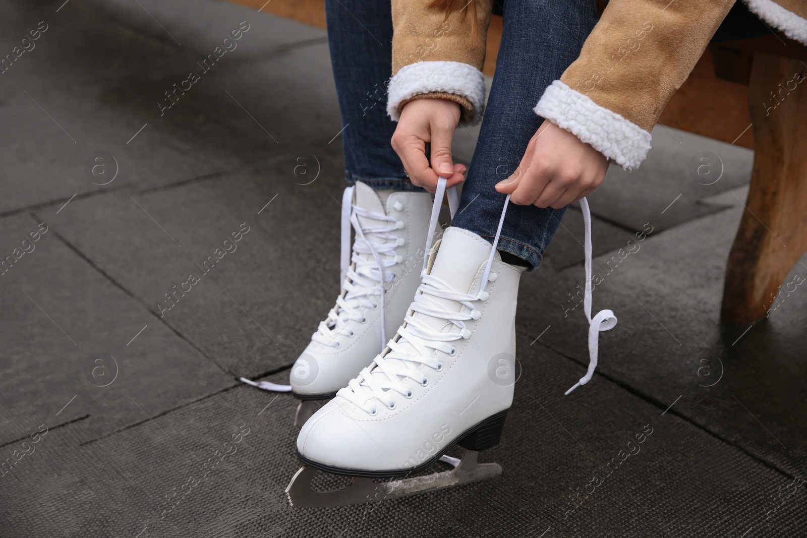 Woman lacing figure skate outdoors, closeup view Photo of Woman lacing figure skate outdoors, closeup view