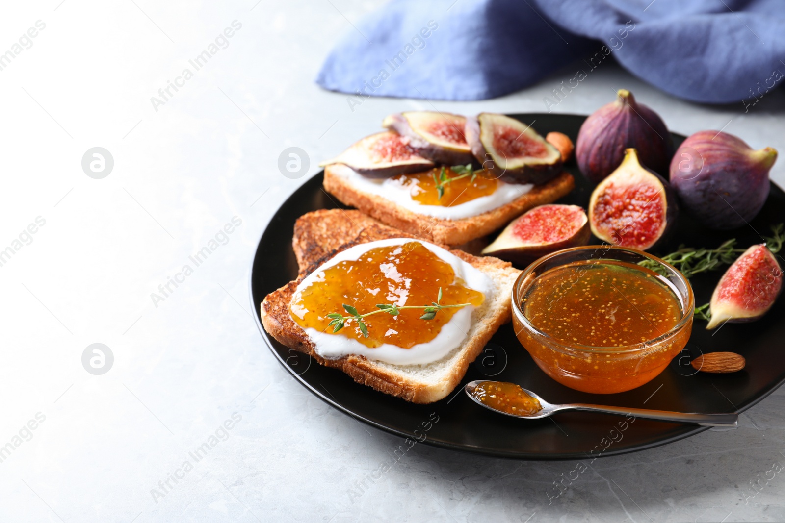 Tasty toasts with fig jam and cream cheese on grey marble table, closeup Photo of Tasty toasts with fig jam and cream cheese on grey marble table, closeup