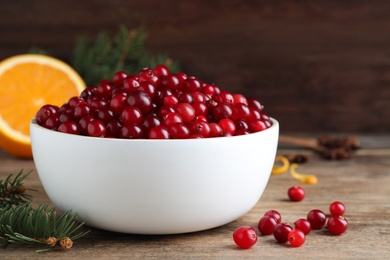 Fresh ripe cranberries and fir branch on wooden table. Space for text Photo of Fresh ripe cranberries and fir branch on wooden table. Space for text