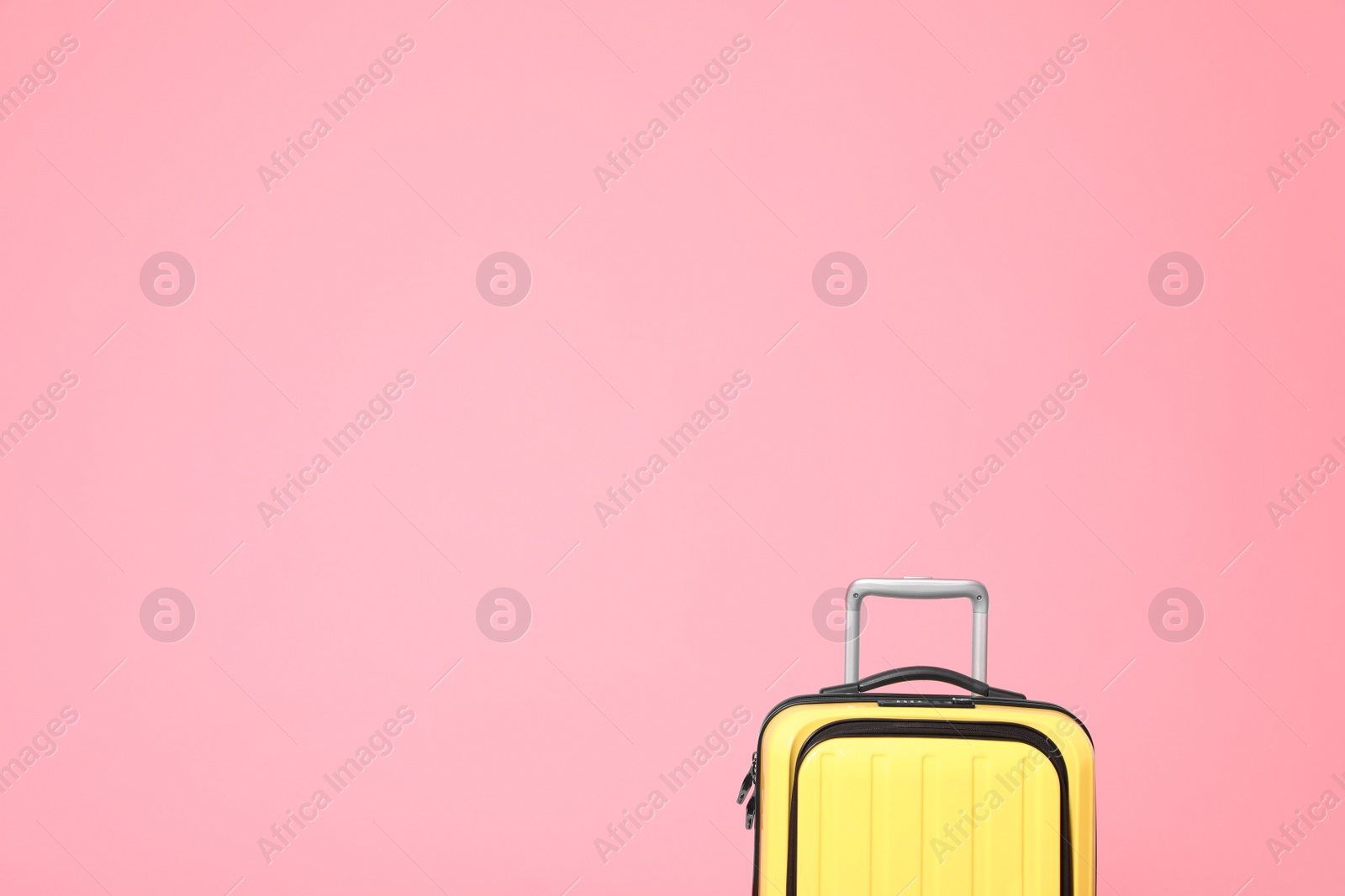 Photo of Stylish yellow suitcase on pink background. Space for text