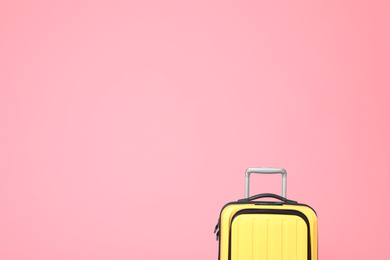 Photo of Stylish yellow suitcase on pink background. Space for text
