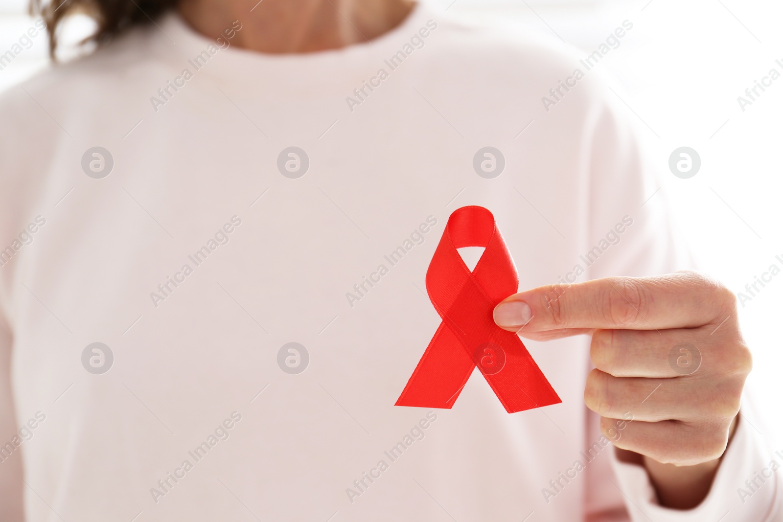 Woman holding red awareness ribbon, closeup with space for text. World AIDS disease day Photo of Woman holding red awareness ribbon, closeup with space for text. World AIDS disease day