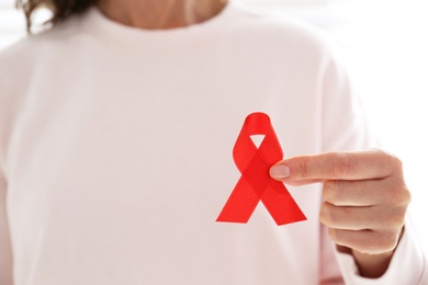 Woman holding red awareness ribbon, closeup with space for text. World AIDS disease day Photo of Woman holding red awareness ribbon, closeup with space for text. World AIDS disease day