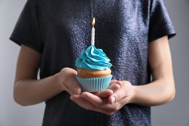 Woman holding birthday cupcake, closeup Photo of Woman holding birthday cupcake, closeup