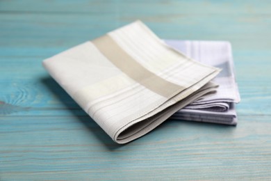 Stylish handkerchiefs on light blue wooden table Photo of Stylish handkerchiefs on light blue wooden table
