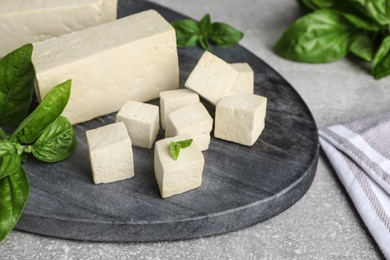 Delicious tofu with basil on grey table, closeup Photo of Delicious tofu with basil on grey table, closeup