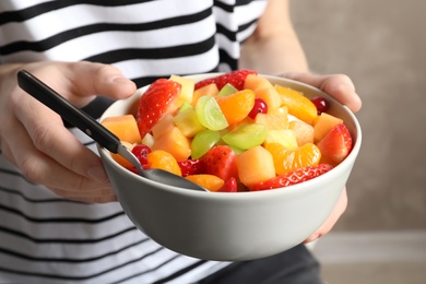 Woman with bowl of fresh fruit salad, closeup Photo of Woman with bowl of fresh fruit salad, closeup