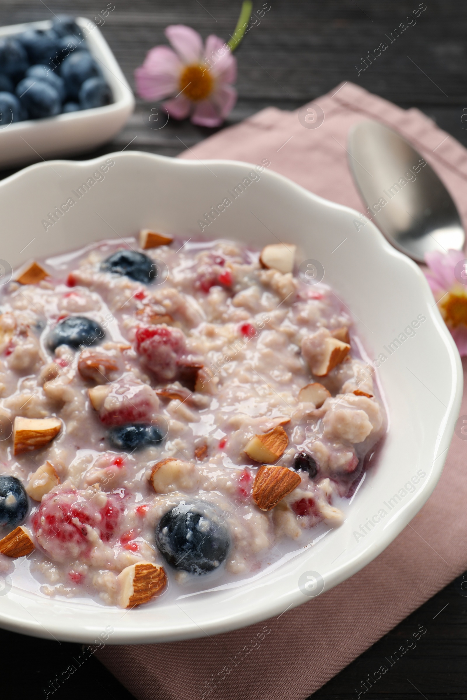 Tasty oatmeal porridge with toppings on wooden table, closeup Photo of Tasty oatmeal porridge with toppings on wooden table, closeup