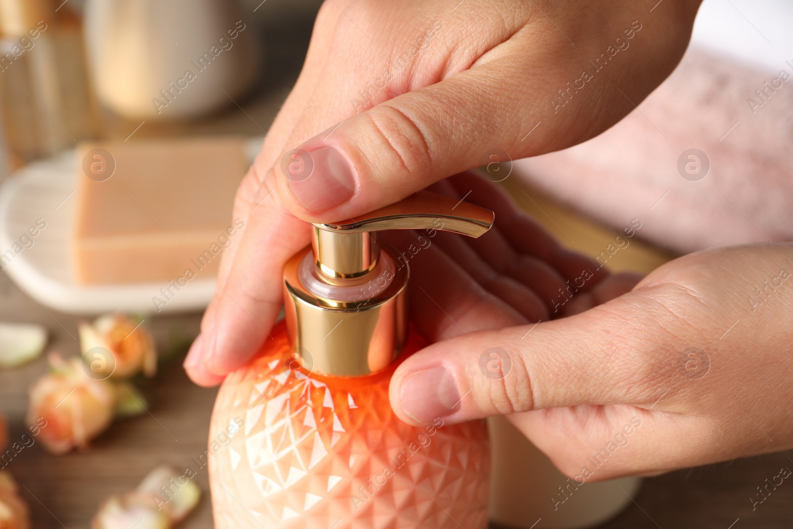 Woman using liquid soap dispenser, closeup view Photo of Woman using liquid soap dispenser, closeup view