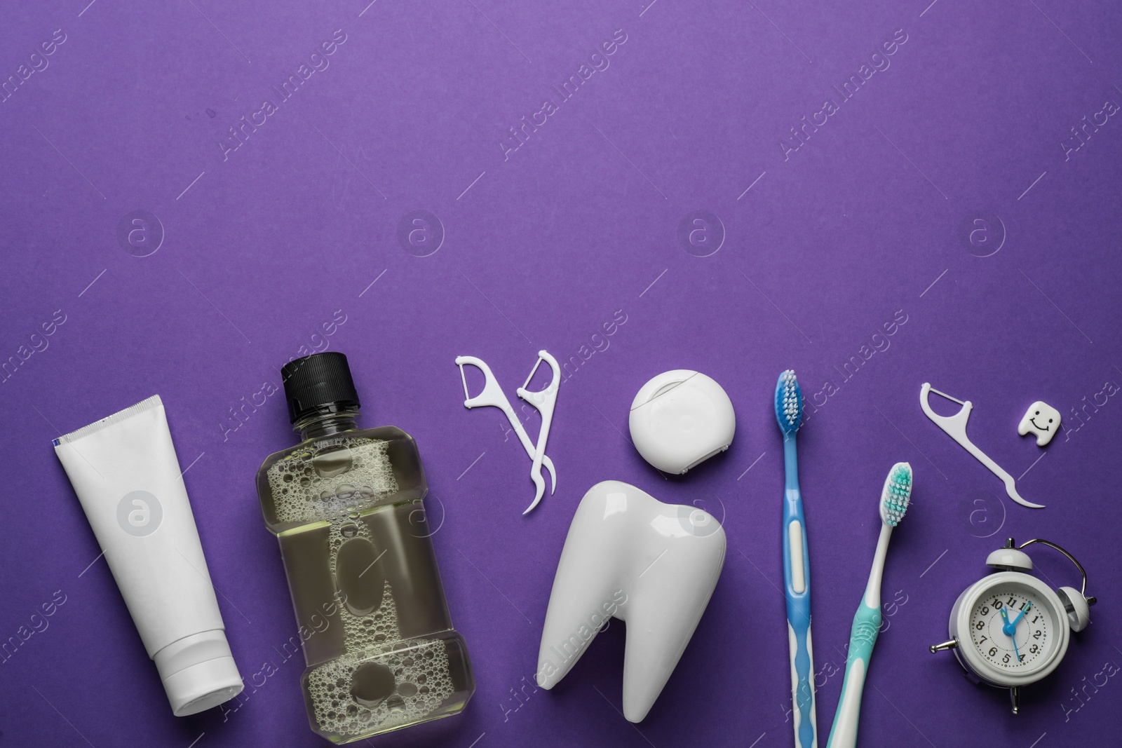 Flat lay composition with mouthwash and other oral hygiene products on purple background. Space for text Photo of Flat lay composition with mouthwash and other oral hygiene products on purple background. Space for text