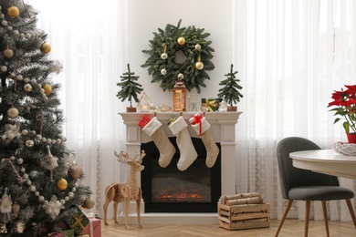 Fireplace in room with Christmas decorations. Interior design Photo of Fireplace in room with Christmas decorations. Interior design