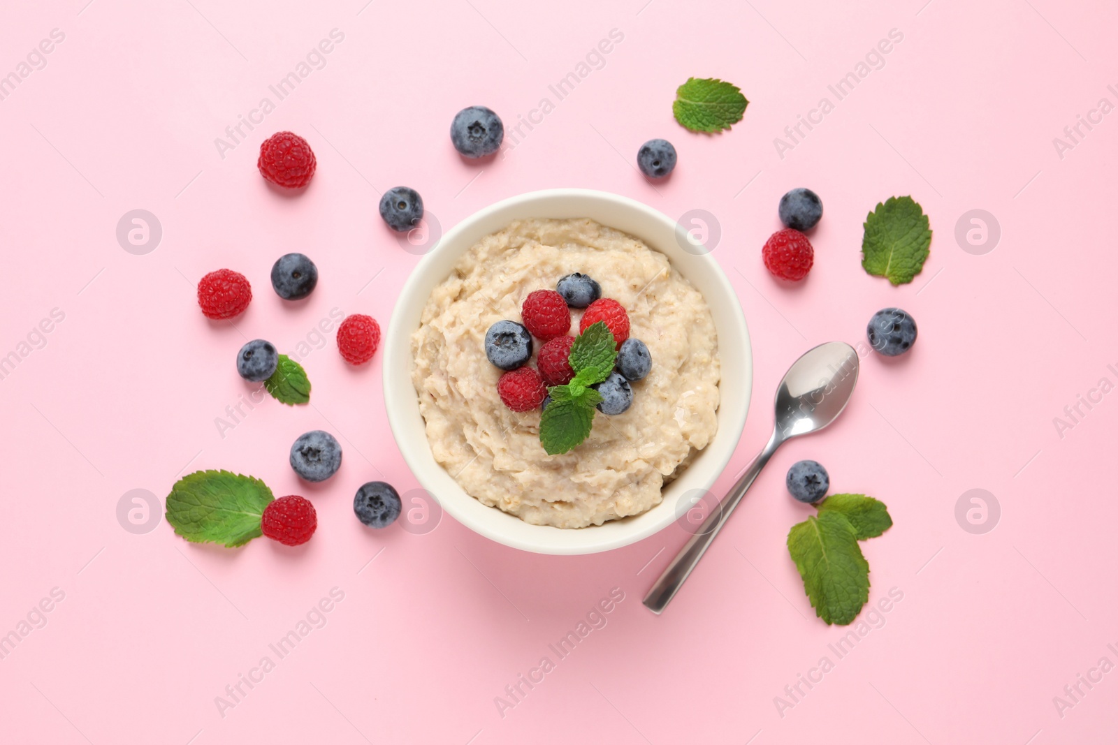 Tasty oatmeal porridge with raspberries and blueberries in bowl on pink background, flat lay Photo of Tasty oatmeal porridge with raspberries and blueberries in bowl on pink background, flat lay